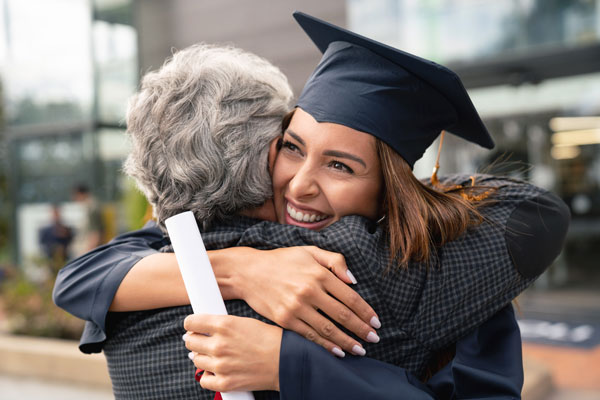 Graduating student hugging an older lady.